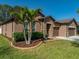 Front yard featuring well manicured landscaping, lush green grass, and a two car garage at 1525 Banner Elk St, Valrico, FL 33594