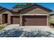 Close up of two car garage featuring stone accents and a concrete driveway at 1525 Banner Elk St, Valrico, FL 33594