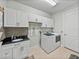 Well-equipped laundry room with sink, cabinets, and modern washer/dryer at 1525 Banner Elk St, Valrico, FL 33594