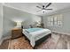 Main bedroom offers wood floors, ceiling fan and a side table at 1525 Banner Elk St, Valrico, FL 33594