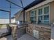 This screened-in outdoor kitchen area showcases a built-in gas grill and convenient storage at 1525 Banner Elk St, Valrico, FL 33594