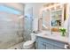 Modern bathroom with walk-in shower, gray vanity, and pebble floor at 1818 4Th E St, Palmetto, FL 34221