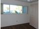 Bedroom with large window, built-in cabinets, and wood-look floors at 2020 N World Parkway Blvd # 12, Clearwater, FL 33755