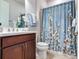 Clean bathroom with a shower/tub combo, wood vanity, and floral shower curtain at 20292 Sea Glass Cir, Land O Lakes, FL 34638