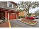 Attached garage with red door and landscaping, in a community setting at 2254 Chianti Pl # 68, Palm Harbor, FL 34683