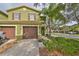 Green two-story townhome with brown garage doors and landscaping at 2803 Santego Bay Ct, Brandon, FL 33511