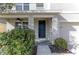 Dark-colored front door with a covered entryway and landscaping at 30755 Summer Sun Loop, Wesley Chapel, FL 33545