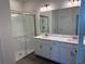 Modern bathroom featuring double sinks, granite countertops, and a glass enclosed shower at 31819 Cardinal Yard Dr, San Antonio, FL 33576