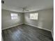 Spacious bedroom with wood-look floors and two windows at 3341 Wiltshire Dr, Holiday, FL 34691