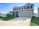 Two-story house with gray siding, dark shutters, and a two-car garage at 35474 Quartz Lake Dr, Zephyrhills, FL 33541