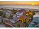 Sunset aerial view of beachfront neighborhood with the yellow house having a red tile roof at 3702 El Centro St, St Pete Beach, FL 33706