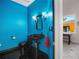 Modern powder room with blue walls, black fixtures, and unique design elements at 3702 El Centro St, St Pete Beach, FL 33706