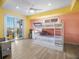 Colorful bedroom featuring a bunk bed, ceiling fan, and outdoor balcony at 3702 El Centro St, St Pete Beach, FL 33706