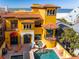 Striking yellow home with a pool, spa, and terracotta tile roof at 3702 El Centro St, St Pete Beach, FL 33706