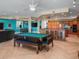 Spacious game room features a pool table, built-in bar, and views to the kitchen and dining areas at 3702 El Centro St, St Pete Beach, FL 33706