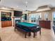 Open-concept game room features a billiards table, fireplace, bar area, and ocean views through sliding glass doors at 3702 El Centro St, St Pete Beach, FL 33706