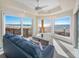 Bright living room featuring ocean views from three large windows and beachside furniture at 3702 El Centro St, St Pete Beach, FL 33706