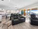 Spacious living room with theater seating, wood floors, sliding glass doors to balcony with ocean view at 3702 El Centro St, St Pete Beach, FL 33706