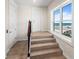 Stairway with wood treads, white walls, and a window offering ocean views at 3702 El Centro St, St Pete Beach, FL 33706