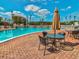 Inviting pool area with tables, chairs, and umbrellas for shade at 3717 Trophy Blvd, New Port Richey, FL 34655