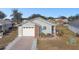 Ranch-style home with brick and gray siding, a garage, and landscaping at 37401 Wedgewood Dr, Zephyrhills, FL 33542