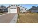 Gray house with brick accents, attached garage, and landscaped front yard at 37401 Wedgewood Dr, Zephyrhills, FL 33542