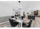 Elegant dining room with a white table and black chairs, offering a kitchen view at 3915 Briarlake Dr, Valrico, FL 33596