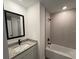 Bathroom with tub, granite vanity, and modern fixtures at 4294 Danbury St, North Port, FL 34286