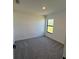 Bright bedroom with grey carpeting and large window at 4294 Danbury St, North Port, FL 34286