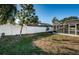 A well-maintained lawn, white fence, and screened-in pool in the backyard create a private oasis at 435 Laughing Gull Ln, Palm Harbor, FL 34683