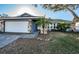 Single-story home features a two-car garage, stone accents, and a well-maintained front yard at 435 Laughing Gull Ln, Palm Harbor, FL 34683