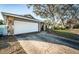 Spacious two-car garage with stone accents and a long driveway, surrounded by mature trees at 435 Laughing Gull Ln, Palm Harbor, FL 34683