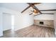 Living room with wood floors, ceiling fan, beamed ceilings, and a stone fireplace at 435 Laughing Gull Ln, Palm Harbor, FL 34683