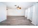 Open living room with wood-look flooring, neutral walls, and large windows dressed with white curtains at 435 Laughing Gull Ln, Palm Harbor, FL 34683