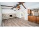 Open living room space featuring wood flooring, stone fireplace, and beamed ceilings at 435 Laughing Gull Ln, Palm Harbor, FL 34683