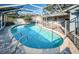 Screened-in pool featuring clear blue water, brick trim, lounge seating, and an attached patio at 435 Laughing Gull Ln, Palm Harbor, FL 34683