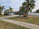 Newly painted ranch home with a long driveway and palm trees at 4701 Lodestone Dr, Tampa, FL 33615