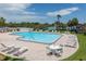 Community pool with lounge chairs and waterfront view at 4712 Marine Pkwy # 103, New Port Richey, FL 34652