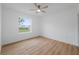 Bright bedroom with wood-look floors and a large window offering a tranquil view at 4829 Jenny Way, New Port Richey, FL 34652