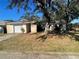 Ranch-style house with a white garage door and mature trees in the front yard at 5205 Landsman Ave, Tampa, FL 33625