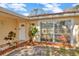 Charming home entrance featuring a white front door, decorative plants, and meticulous landscaping at 5205 Landsman Ave, Tampa, FL 33625