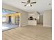 Open-concept living room featuring light wood flooring, a ceiling fan, and sliding glass doors to the patio at 5205 Landsman Ave, Tampa, FL 33625