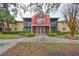 Two-story condo building with red exterior, screened patios, and landscaping at 5557 Baywater Dr, Tampa, FL 33615