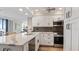 Modern kitchen with white cabinets, herringbone backsplash, and stainless steel appliances at 629 Alhambra Rd # 604, Venice, FL 34285