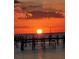 Silhouetted pier at sunset over calm water at 6504 Surfside Blvd # 5, Apollo Beach, FL 33572