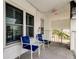 Small balcony with two blue chairs and a small table at 680 71St Ave # 14, St Pete Beach, FL 33706