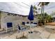 Outdoor patio furniture with blue chairs and umbrella at 680 71St Ave # 14, St Pete Beach, FL 33706