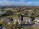 Aerial view of townhomes with lush surroundings, showcasing a desirable neighborhood and serene environment, with lake view at 6972 Ripple Pond Loop, Zephyrhills, FL 33541