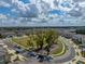 Aerial view of the neighborhood with homes situated around grassy park and views of mature trees at 6972 Ripple Pond Loop, Zephyrhills, FL 33541