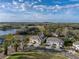 Stunning aerial view of townhomes nestled in a picturesque community with lush landscaping and a peaceful atmosphere, near lake at 6972 Ripple Pond Loop, Zephyrhills, FL 33541